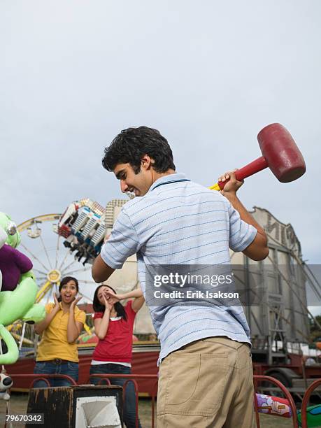 mixed race teenaged boy playing carnival game  - strength tester stock pictures, royalty-free photos & images