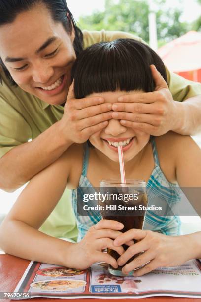 asian man covering girlfriend's eyes - asian female friends drinking soda outdoor stock pictures, royalty-free photos & images