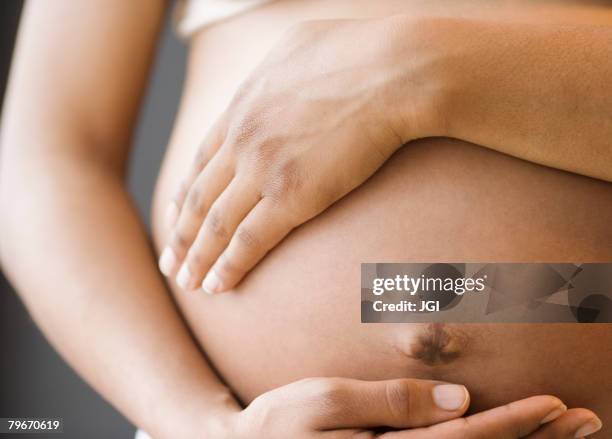 close up of pregnant african american woman's belly - pregnant belly stock pictures, royalty-free photos & images