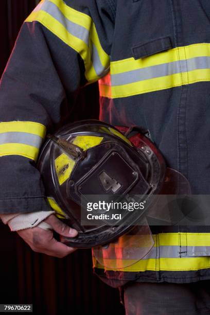 hispanic male firefighter holding helmet - capacete de bombeiro - fotografias e filmes do acervo
