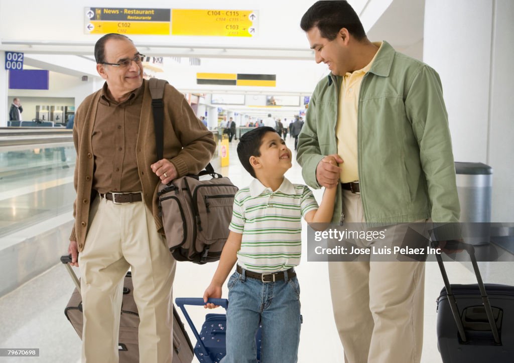 Hispanic grandfather, father and son at airport