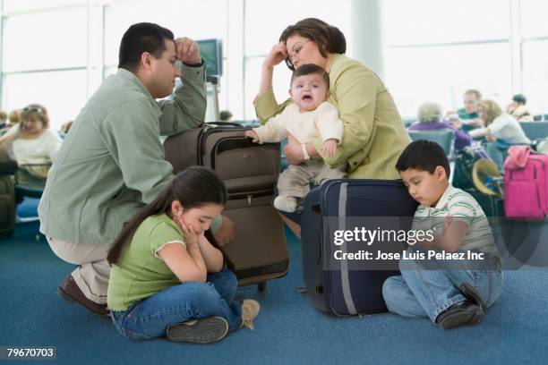 multi-ethnic family waiting in airport - airport sitting family stock pictures, royalty-free photos & images