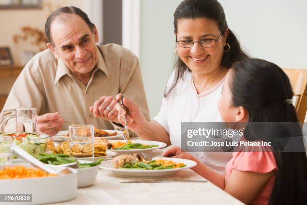 hispanic family at dinner table - puertorriqueño fotografías e imágenes de stock