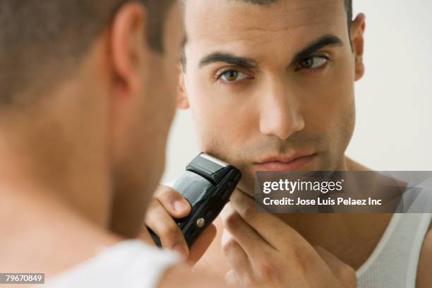 hispanic man shaving with electric razor - shaving 個照片及圖片檔