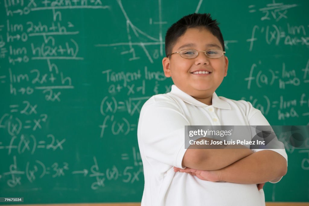 Hispanic boy in front of blackboard