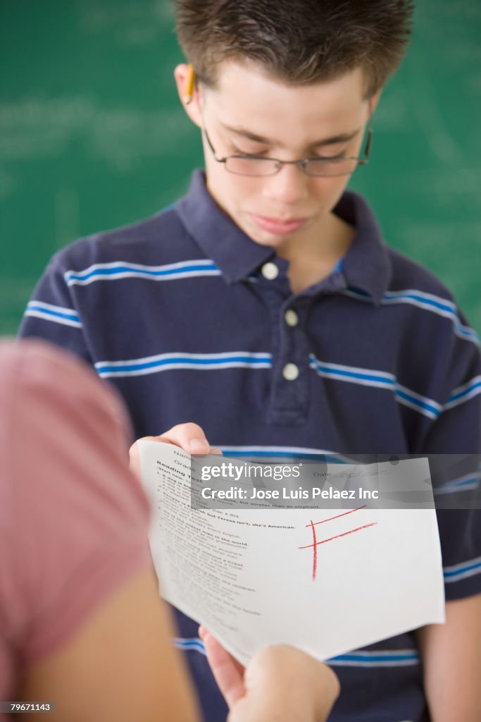Hispanic woman getting school paper with F grade