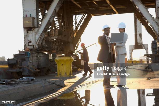 african american businesspeople wearing hardhats - african creative with laptop working outside stockfoto's en -beelden