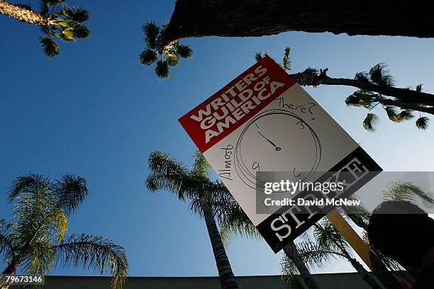 Picket sign addresses the question of whether the strike may end soon while Writers Guild of America members and supporters picket in front of NBC...