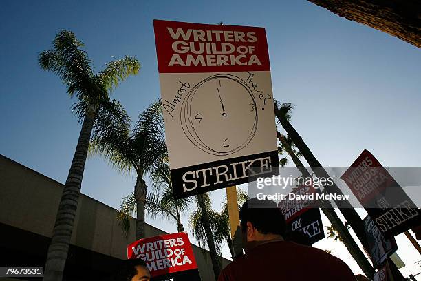 Picket sign addresses the question of whether the strike may end soon while Writers Guild of America members and supporters picket in front of NBC...