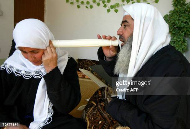 Sheikh Abdul Wahab performs rituals aimed to expel evil spirits from the body of a Kurdish woman in the northern city of Arbil on February 3, 2008. A...