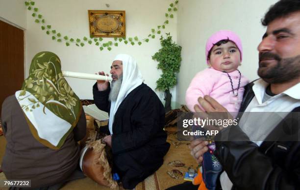 Sheikh Abdul Wahab performs rituals aimed to expel evil spirits from the body of a Kurdish woman in the northern city of Arbil on February 3, 2008. A...