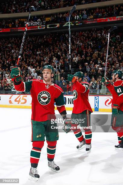 Marian Gaborik, Branko Radivojevic, and Martin Skoula of the Minnesota Wild celebrate after defeating the New York Islanders at Xcel Energy Center on...