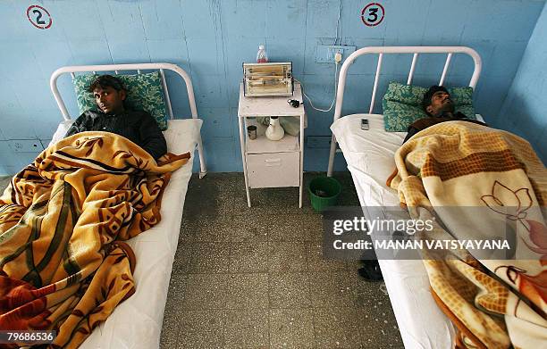 In this picture taken January 29 Indian labourers Mohammad Salim and Shakeel Ahmed , rest on hospital beds in Gurgaon some 30 kms south of New Delhi,...