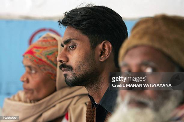 In this picture taken January 29 Indian labourer Shakeel Ahmed rests on a hospital bed with his parents in Gurgaon some 30 kms south of New Delhi,...