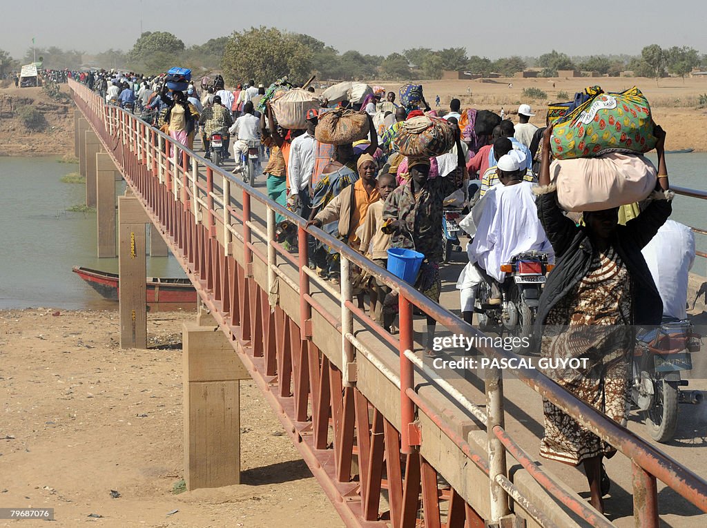 Chadian refugees and residents cross on