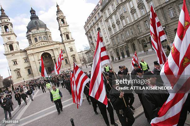 Waving flags, clad in black uniforms of Hungary's Nazi-aligned Arrow Cross party in WWII, local members of the far-right para military Hungarian...