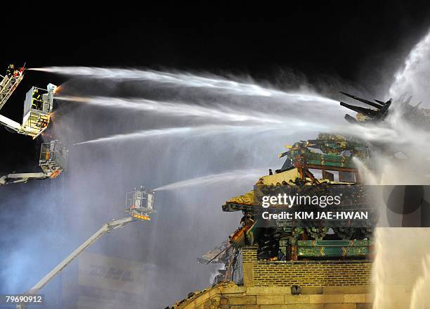 Firefighters battle a blaze at the break down Namdaemun gate, one of South Korea's most historic sites, in central Seoul on February 11, 2008. The...