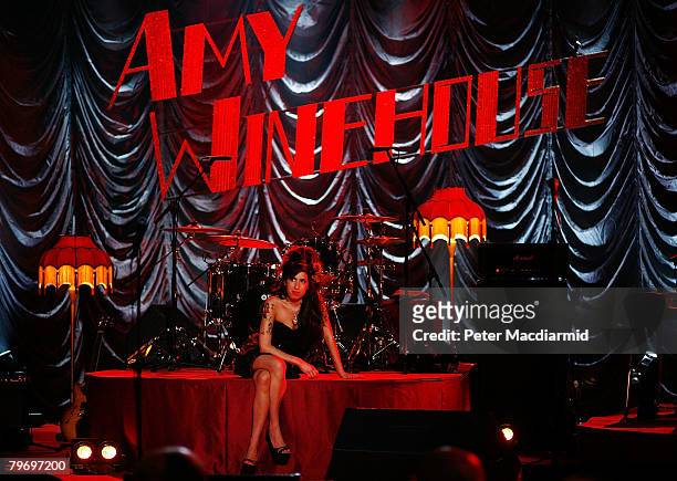 British singer Amy Winehouse sits on stage and looks up at a television monitor whilst awaiting news of her Grammy Award at The Riverside Studios for...