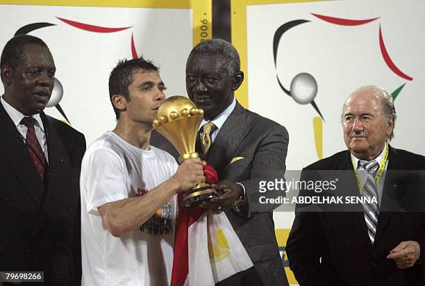 The captain of Egypt's national football team Ahmed Hassan kisses the trophy of the 2008 African Nations Cup he received from Ghanean President John...