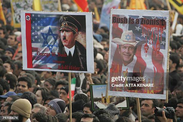 Iranians hold up anti-Bush placards, accusing him of being a Zionist and comparing him with Adolf Hitler, during a rally held in Tehran to mark the...