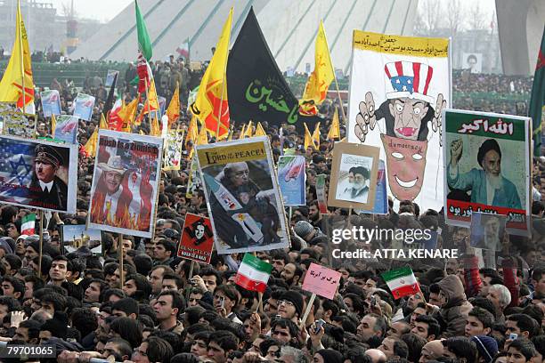 Iranians hold up anti-Bush placards , accusing him of being a Zionist and comparing him with Adolf Hitler, during a rally held in Tehran to mark the...
