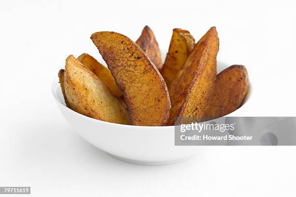 potato wedges in a white bowl, studio shot - potato wedges stock pictures, royalty-free photos & images