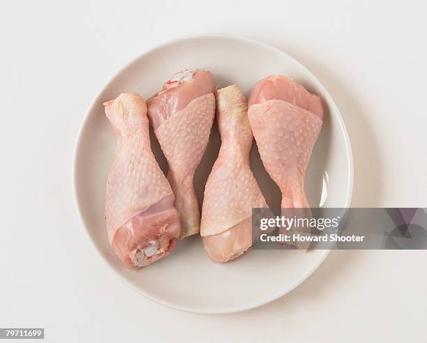 chicken drumsticks on a plate, close up - uncooked chicken photos et images de collection