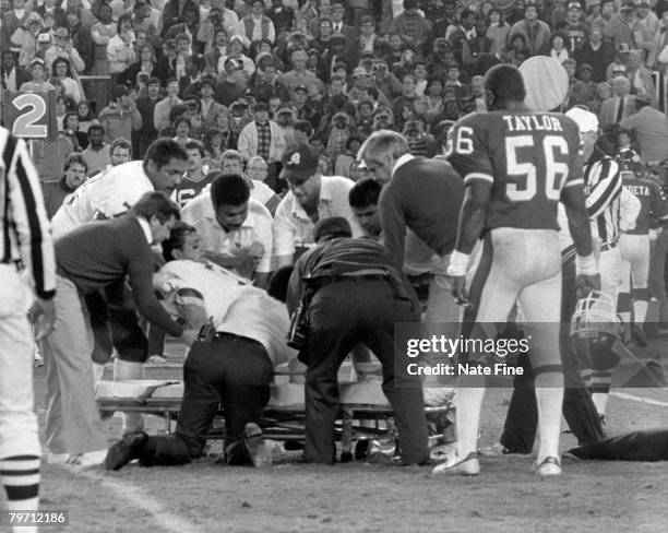 Quarterback Joe Theismann of the Washington Redskins is carted off the field by medical staff after having his leg broken by Giants defensive end...