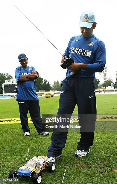 Dhoni of India plays with a remote control car as rain delays play before the Commonealth Bank Series One Day International match between Sri Lanka...