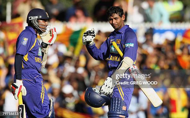 Sri Lankan batsman Tillakaratne Dilshan , watched by teammate Mahela Jayawardene , gives the thumbs up after reaching his 50 during their team's win...