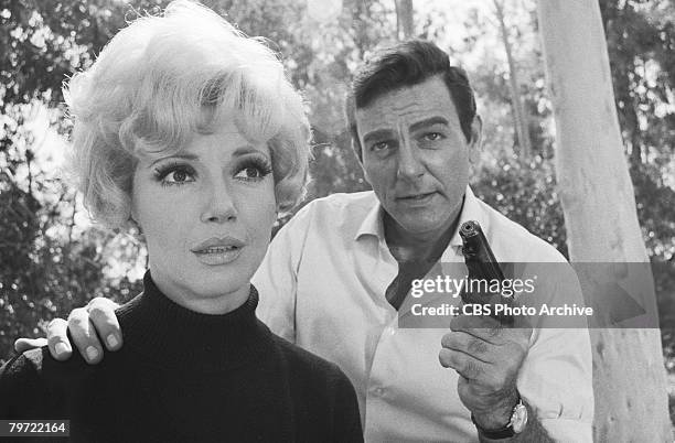 American actor Mike Connors as Joe Mannix and Canadian actress Ruta Lee in the woods in a scene from an episode of the television detective series...