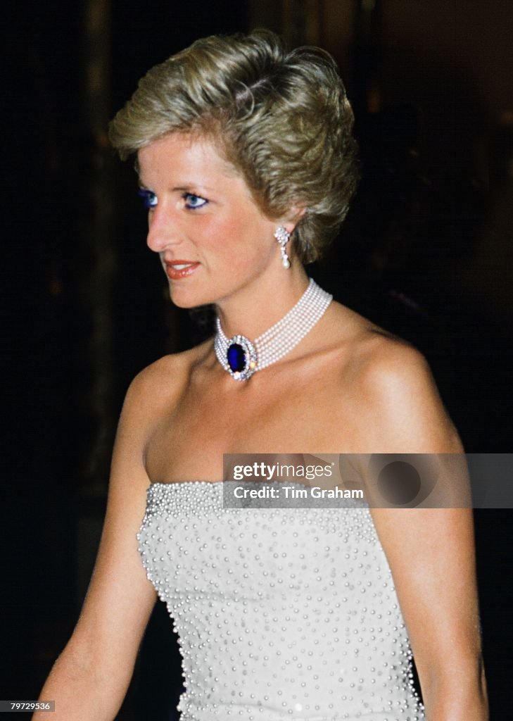 Princess Diana wearing a white strapless dress, embroidered
