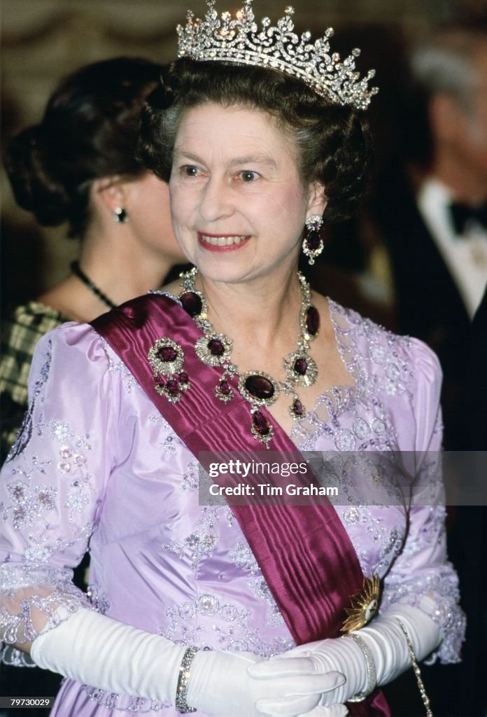 Queen Elizabeth II in Portugal wears a necklace and brooch o