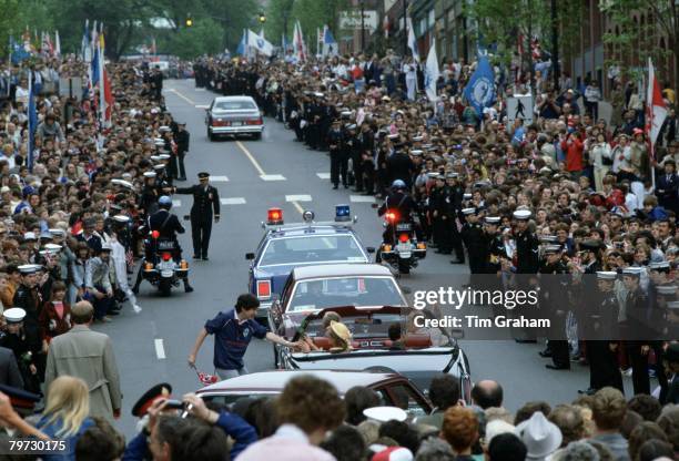 Prince Charles and Princess Diana in an open-topped car travel in convoy during a visit to St John in Canada