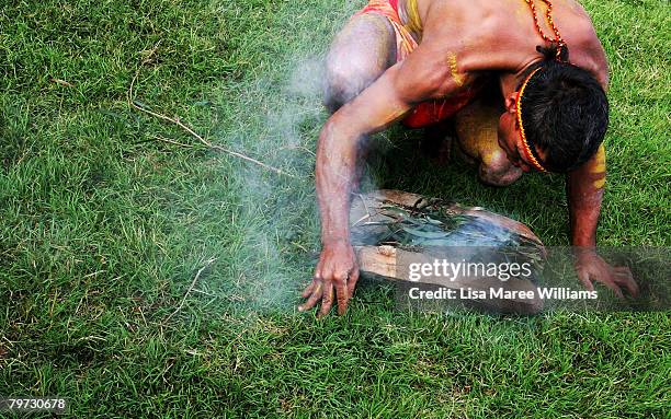 An Aboriginal man performs a smoke cleansing ritual on the Parliament lawns as Australian Prime Minister Kevin Rudd delivers an apology to the...