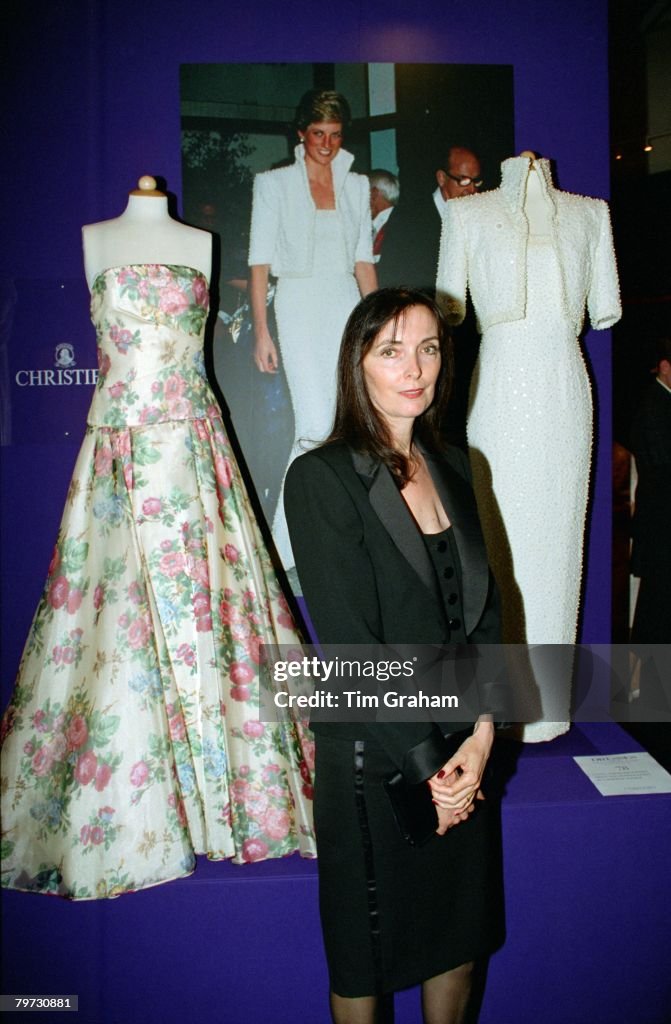 Dress designer Catherine Walker posing in front of one of he