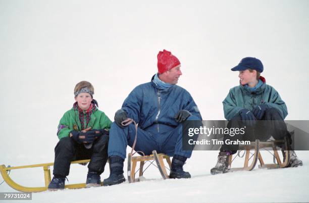 Prince Charles, Prince of Wales with his sons Prince William and Prince Harry on sledges whilst on holiday in Klosters