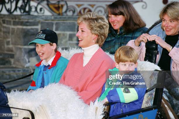 Diana, Princess of Wales with Prince William and Prince Harry in a sleigh during a skiing holiday in Lech, Austria, Sitting behind them are Diana's...