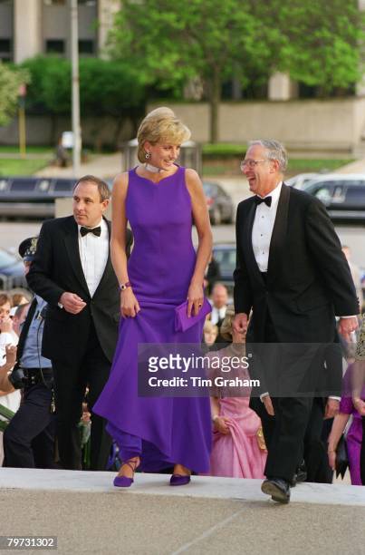 Diana, Princess of Wales arriving for a gala dinner in Chicago, Her dress is by designer Versace and her shoes by Jimmy Choo, Immediately behind...