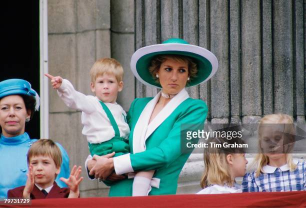 Diana, Princess of Wales, holding a young Prince Harry in her arms as she watches Trooping the Colour with Prince William, Lady Rose Windsor, Lady...
