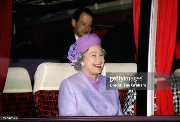 Queen Elizabeth ll laughs on a coach on her way to visit the Oberspree factory in Berlin