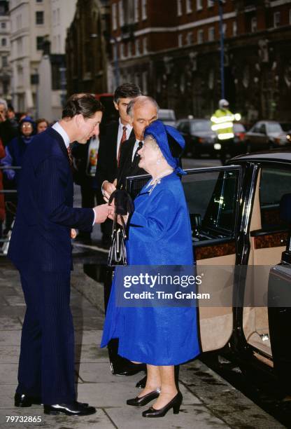 Prince Charles, Prince of Wales greets the Queen Mother as she arrives by car for their visit to the Royal College of Music at Green Park