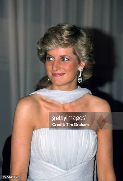 Diana, Princess of Wales attends the Cannes film festival wearing a pale blue chiffon dress and wrap designed by fashion designer Catherine Walker