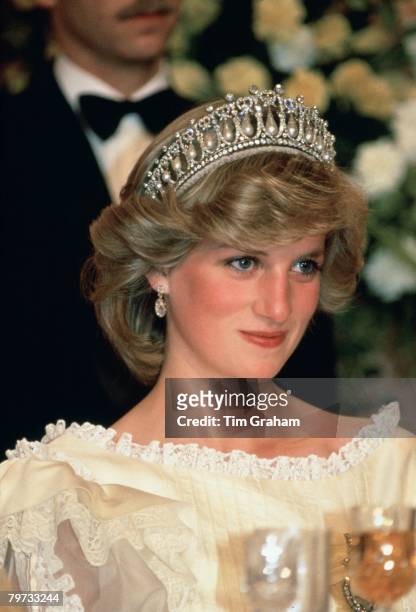 Diana, Princess of Wales at a banquet in New Zealand wearing the Cambridge knot tiara , Her cream silk organza evening dress is designed by fashion...