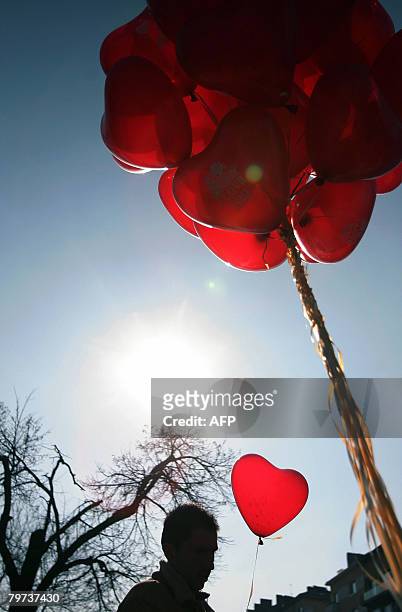 Man buys a heart-shaped balloon from a street vendor in downtown Sofia, on February 13, 2008 on the eve of St. Valentine's Day. Valentine's Day is a...