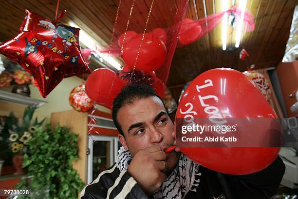 Palestinian flower vender decorates his shop as he prepares to celebrate on the eve of Valentine's Day on February 13, 2008 in Gaza city, Gaza Strip....