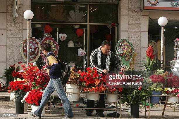 Palestinian flower vender decorates his shop as he prepares to celebrate on the eve of Valentine's Day on February 13, 2008 in Gaza city, Gaza Strip....