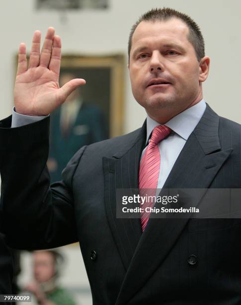 Major League Baseball player Roger Clemens raises his right hand as he is sworn in during a House Oversight and Government Reform Committee, February...