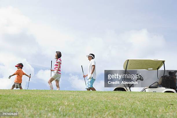 family with son (6-7) marching in line - golf short iron stock pictures, royalty-free photos & images