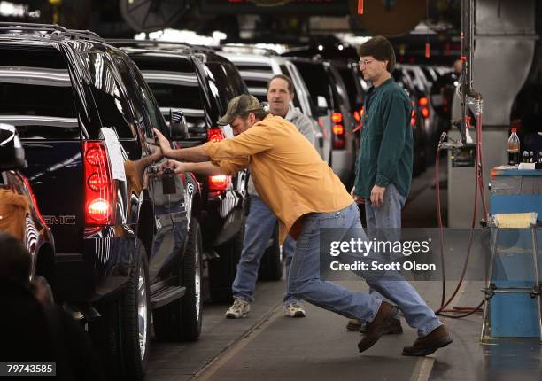 Workers at a General Motors Assembly plant make final adjustments to SUVs coming down the assembly line February 13, 2008 in Janesville, Wisconsin....